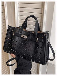 Close-up of black lychee grain leather tote with hollow punch detail and metal twist lock