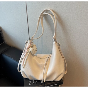 Detail of cream large tote bag with zipper tassel and cute plush bear keychain