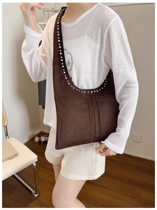 Détail du sac hobo en daim marron foncé avec rivets argentés et coutures fines