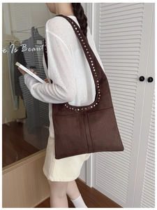 Détail du sac hobo en daim marron avec rivets métalliques et grande capacité de rangement
