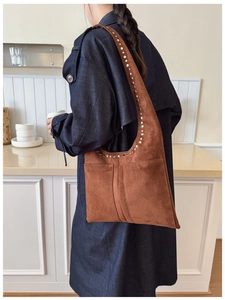 Détail du sac fourre-tout en daim marron vintage avec rivets métalliques et deux poches