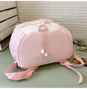 Detailed view of pink and white canvas backpack with cartoon print and elastic cord design