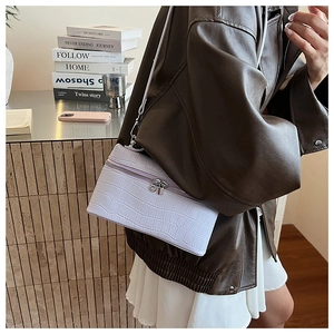 Close-up of lilac crocodile embossed leather square bag with silver metal zipper