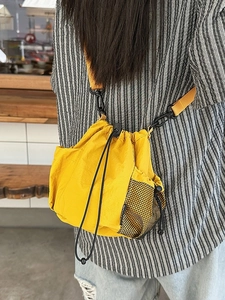 Waterproof yellow nylon drawstring crossbody bucket bag with black mesh pockets for women