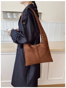 Détail du sac cabas en daim marron avec garniture en rivets argentés et grandes poches