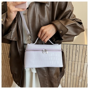Detail of lavender crocodile pattern vanity case bag with top handle and silver hardware