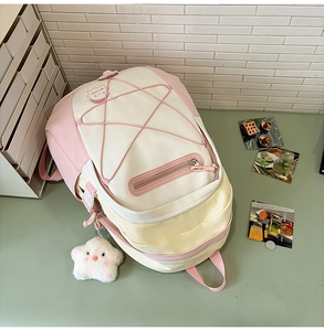 Detail of pink and beige canvas backpack featuring star elastic cord and plush star charm