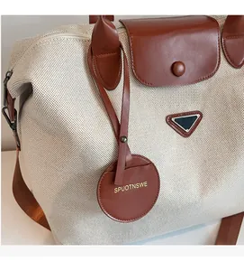 Detail of the woven canvas texture with leather flap and metal triangle emblem