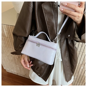 Detailed texture of lavender crocodile pattern handbag with elegant top handle strap