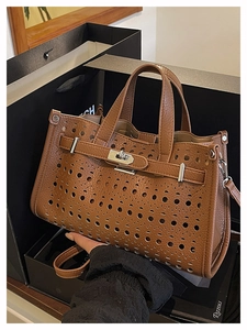 Macro detail of brown hollow-out leather texture with metallic twist lock on handbag