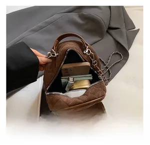 Internal capacity of brown quilted suede backpack showing phone and makeup items