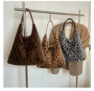 Close-up of fluffy leopard print faux fur tote bags hanging on a metal rack
