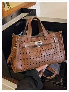 Detailed macro shot of caramel brown perforated leather tote with silver metal twist lock