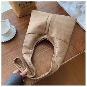 Détail du sac hobo avec rivets métalliques vintage et texture en daim de qualité