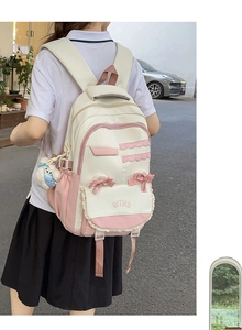 Outdoor shot of cream and pink school backpack with lace, bow, and plush charm