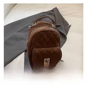 Close-up of quilted matte brown backpack featuring silver twist lock and chain strap