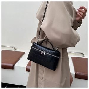 Detail of black faux crocodile texture handbag with silver zipper and metallic hardware