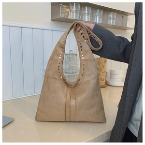 Détails du sac hobo en daim kaki avec des rivets métalliques ronds et des coutures