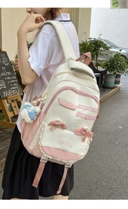 Detail view of pink and white school backpack with lace trim and velvet bow on a model