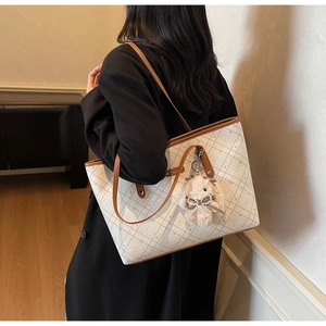Grande borsa tote beige a scacchi con bordi in pelle e ciondolo a forma di coniglio