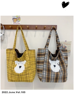 Detail of canvas tote bag showing yellow plaid fabric and cute dog patch embroidery