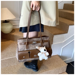 Close-up of brown faux leather tote bag with functional pockets and a cute bear charm
