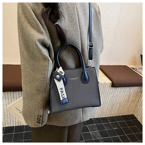 Détail du sac bandoulière bleu marine texturé avec ruban en soie sur blazer en tweed