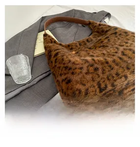 Close-up of leopard print faux fur tote bag with brown faux leather shoulder straps