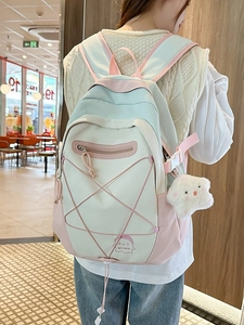 Pastel colorblock student backpack with star charm shown in a bright indoor setting