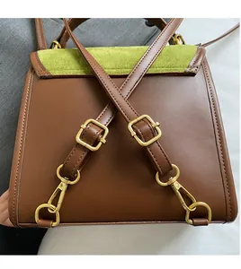 Detail of adjustable golden buckles and green suede flap on a brown leather backpack