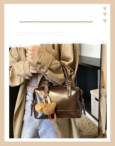 Detail view of deep brown oil wax leather pillow bag with vintage gold metal hardware