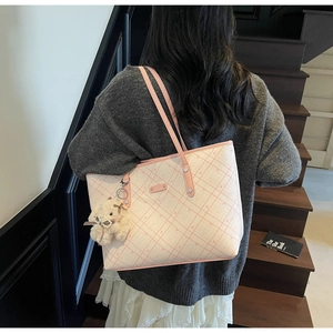 Borsa tote in pelle a scacchi rosa con logo dorato e ciondolo a orsetto sulla spalla