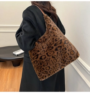 Detailed back view of model wearing a large leopard print faux fur tote bag with leather strap