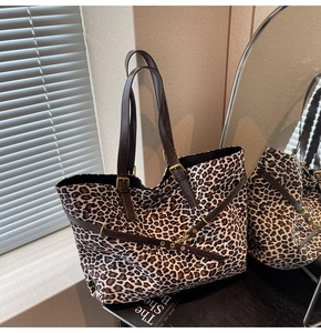 Macro detail of leopard print faux suede tote with brown leather straps and vintage buckles