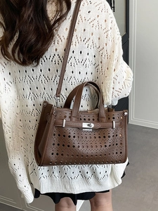 Brown laser-cut hollow leather tote bag with silver turn-lock and adjustable crossbody strap