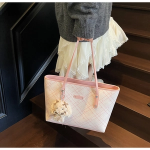 Dettaglio della borsa tote a scacchi rosa e bianca con ciondolo a coniglio e targa con logo