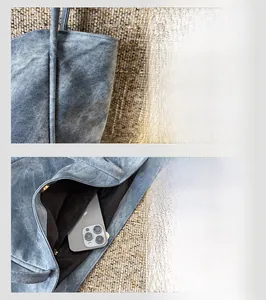 Detail view of denim tote bag showing black lining and interior zipper pocket with phone