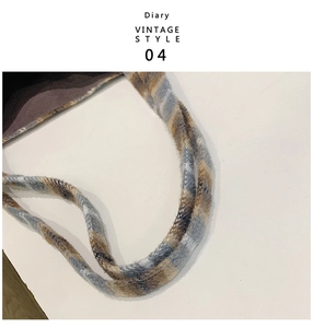 Detail of vintage plaid plush strap with blue and brown stitching and soft texture