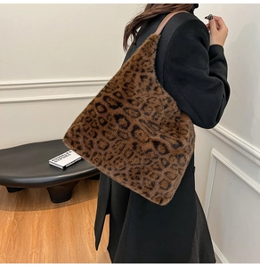 Close-up of leopard print faux fur tote bag with brown leather shoulder strap on a model