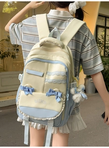 Detail of preppy backpack with lace trim and blue ribbon bow on yellow blue contrast fabric