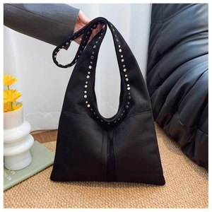 Détail des rivets argentés sur le sac cabas noir en daim au fini mat texturé