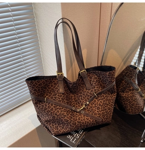 Detailed view of leopard print tote bag with brown leather handles and gold metal hardware