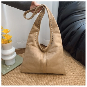 Détail du sac à bandoulière en daim kaki orné de rivets argentés sur la sangle de sac
