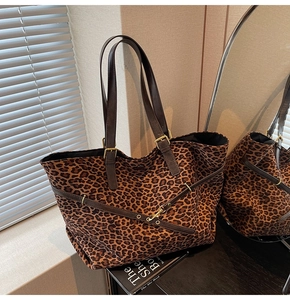 Close-up of leopard print suede tote with faux leather straps and gold buckle detail