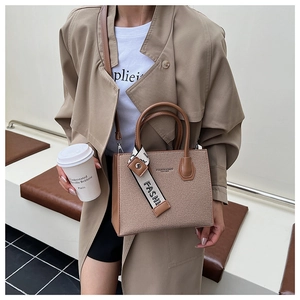 Détail du sac à bandoulière marron avec foulard en soie et gaufrage cuir élégant