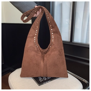 Détail des rivets argentés et de la texture en daim sur un sac hobo marron vintage