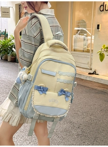 Detail of preppy yellow and blue canvas backpack with lace trims and cute bow decoration