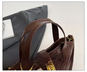 Dettaglio ravvicinato della borsa a secchiello in pelle intrecciata marrone con chiusura oro