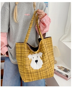 Detail of yellow plaid tote bag with cute white dog applique in a lifestyle setting