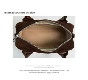 Detailed interior view of the brown suede handbag showing light beige lining and zipper